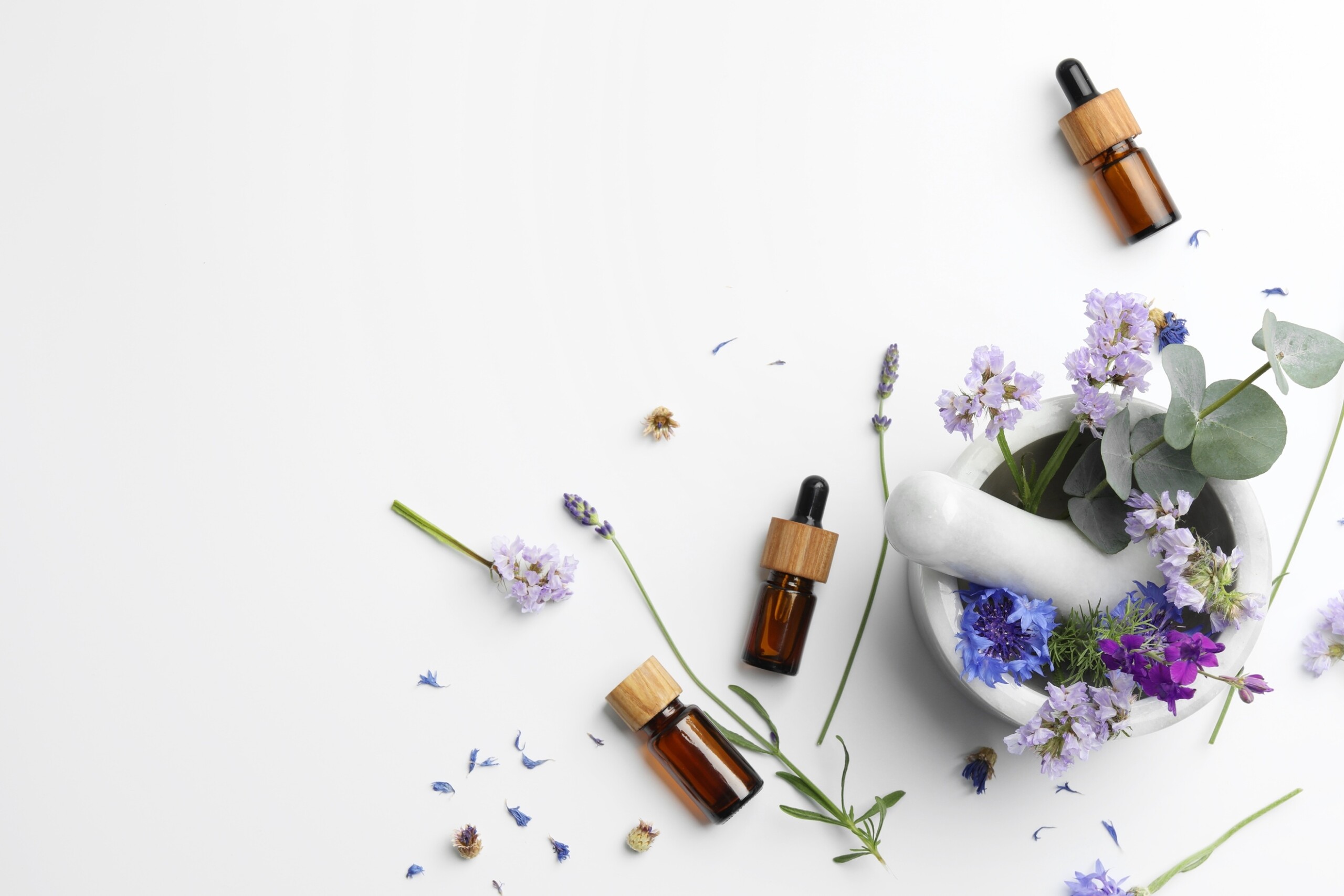 A mortar with flowers and essential oils
Description automatically generated